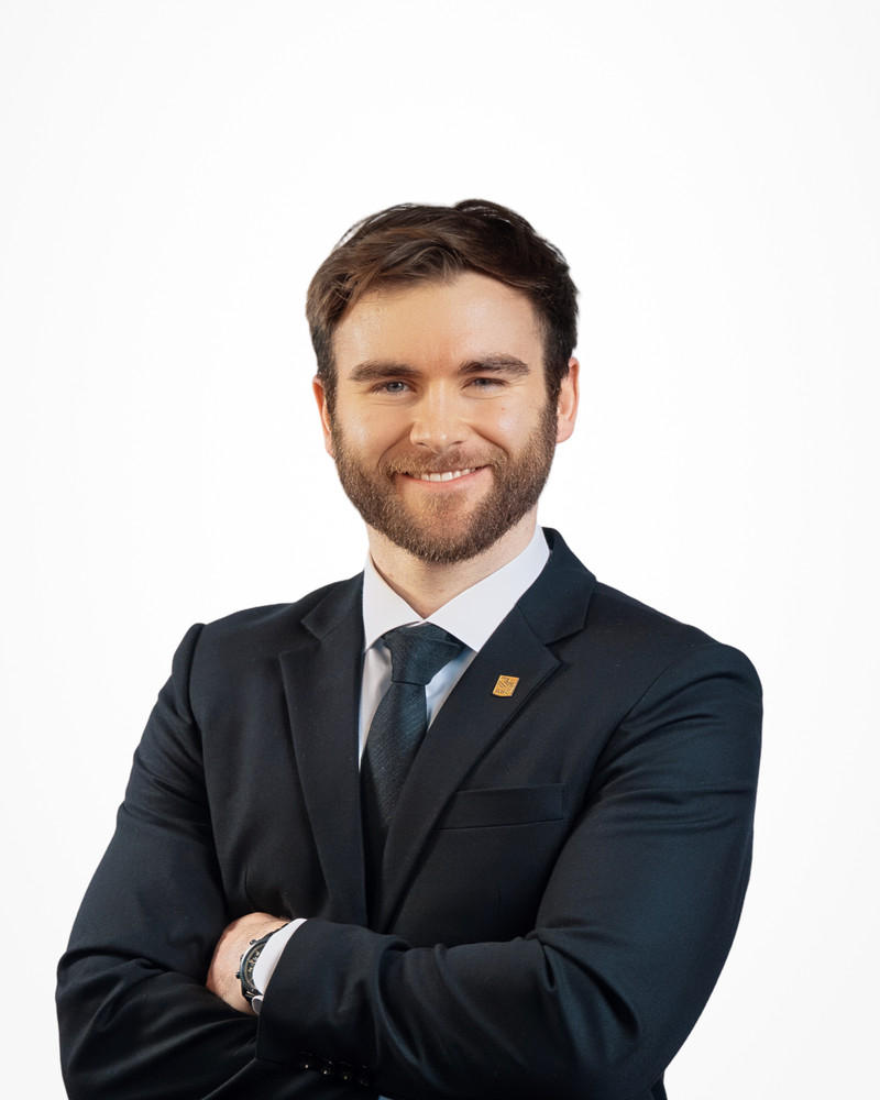 Corporate headshot of a bearded man in a navy suit and tie on a white backdrop, photographed by Jay CS Films