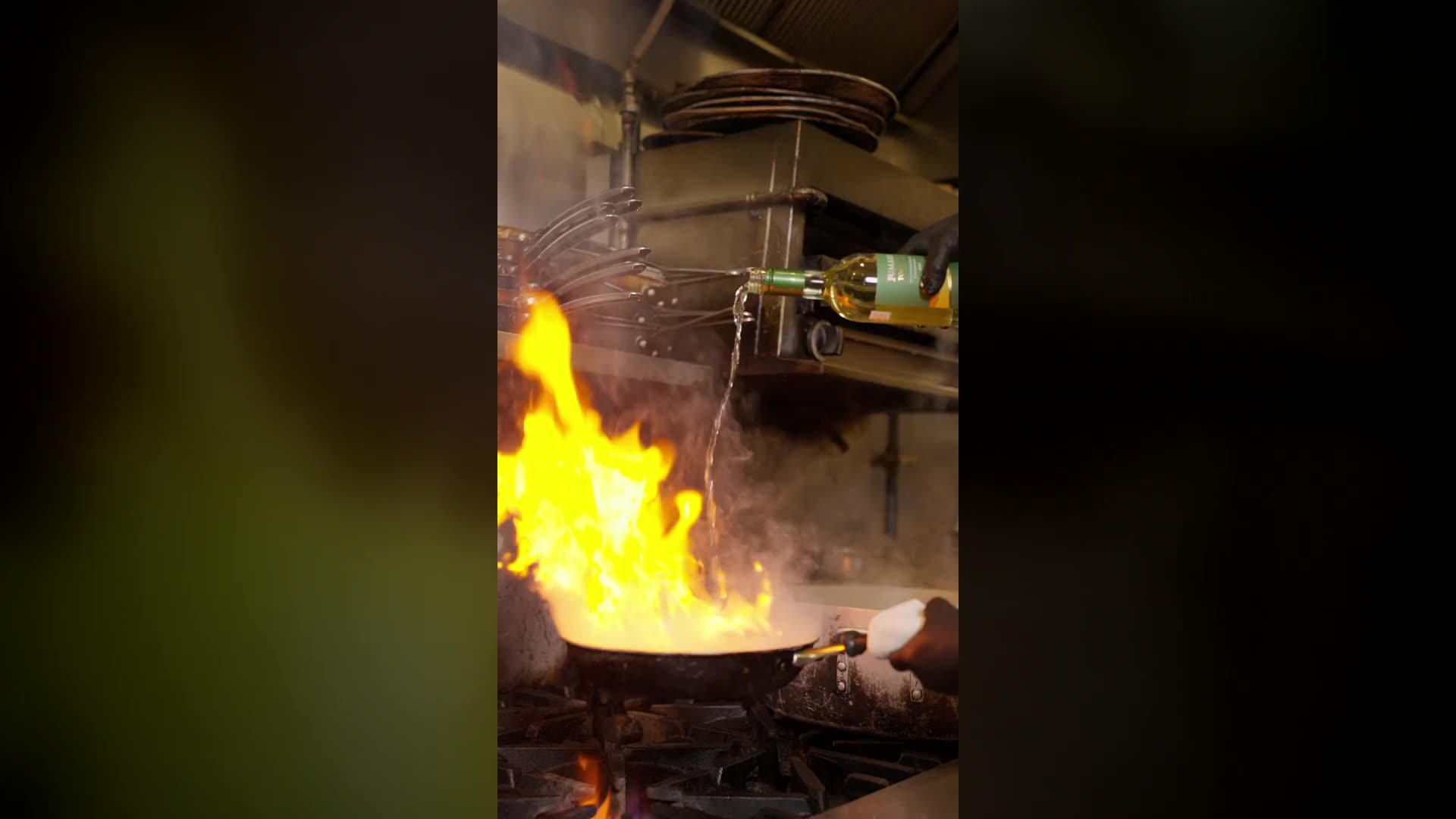 Clams and mussels in a pan over a gas flame, a white-wine flambé with tall flames, then seafood spaghetti tossed and plated with tongs