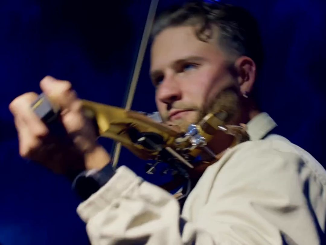 Violinist performing under blue stage light at a corporate gala