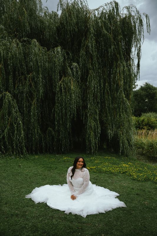 Bride seated on the grass beneath a weeping willow, Montreal wedding photography
