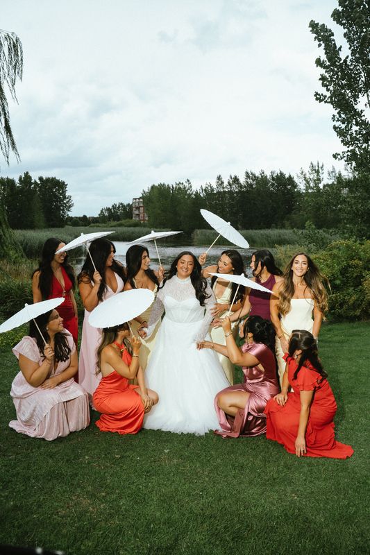 Bride and bridesmaids holding white parasols on the lawn, Montreal wedding photography